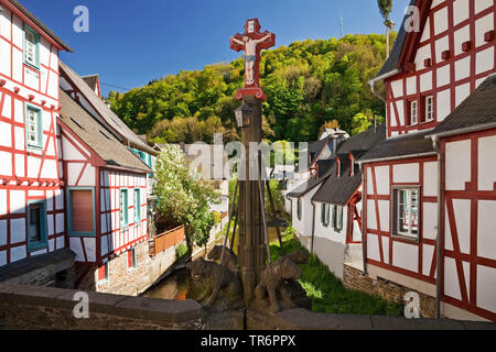 Fachwerkhäuser und Kruzifix an der Elz im historischen Zentrum, Deutschland, Rheinland-Pfalz, Eifel, Monreal Stockfoto