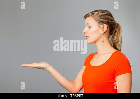 Junge Frau, die etwas auf Ihr Palm, Deutschland Stockfoto