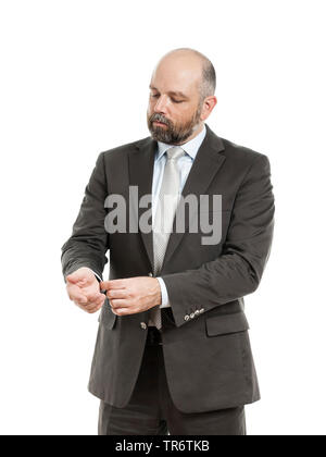 Im mittleren Alter businessmann im kompletten Anzug Einstellen seiner Hülse, Deutschland Stockfoto