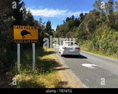 Okarito Kiwi, Rowi, Okarito braun Kiwi (Apteryx rowi), große Schilder an der Straße eingerichtet wurden, um Treiber, achten Sie auf mögliche Okarito Kiwi auf der Straße, eine der seltensten Vogelarten der Welt., Neuseeland, Südinsel, Okarito Stockfoto