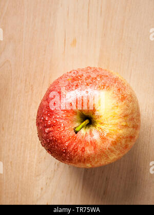 Apfel (Malus Domestica), roter Apfel auf Holzkasten Platte Stockfoto