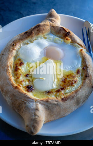 Adjarian khachapuri im Restaurant. Öffnen Brot Kuchen mit Käse und Eigelb. Lecker georgische Küche. Nahaufnahme Stockfoto