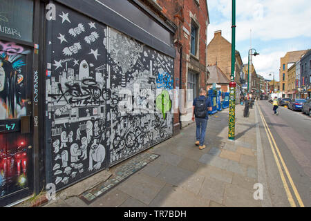 LONDON SPITALFIELDS BRICK LANE GAFFITI UND WALL ART MIT SILBER SPALTE DER MOSCHEE IN DER FERNE Stockfoto