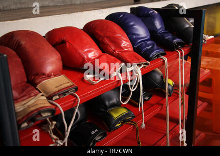 Viele Boxhandschuhe auf dem Regal in der Turnhalle vorbereitet Stockfoto