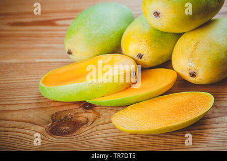 In der Nähe von frischem Grün Dashehari Mangos und die Scheiben auf hölzernen Tisch platziert. Stockfoto