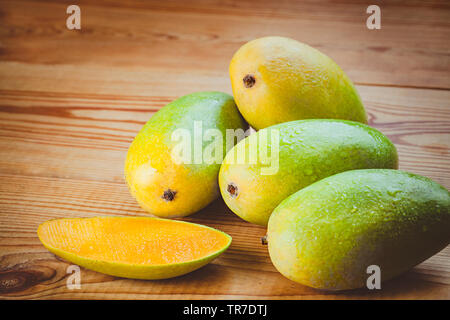 In der Nähe von frischem Grün Dashehari Mangos und die Scheiben auf hölzernen Tisch platziert. Stockfoto