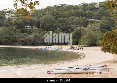 Auf einem ruhigen Sonntagmorgen Kajaks und Kajakfahrer treffen sich auf der ruhigen südlichen Ende des Balmoral Beach in der Vorbereitung für ein Paddel im Hafen von Sydney Stockfoto