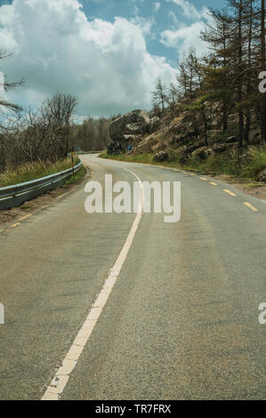 Straße durch einen verbrannten Waldes über einen felsigen Landschaft der Serra da Estrela. Das höchste Gebirge auf dem portugiesischen Festland. Stockfoto