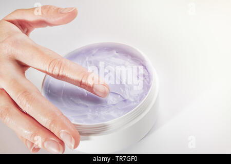 Nahaufnahme von Woman's Hand und feuchtigkeitsspendende Creme für den Körper mit bakuchiol Zutat auf weißem Hintergrund. Isoliert, kopieren. Bakuchiol Konzept. Stockfoto