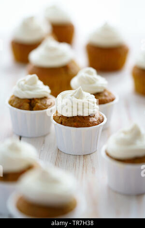 Karotte Cupcakes mit Vanille Glasur. Weiße Holztisch, hohe Auflösung Stockfoto