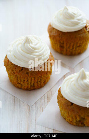 Karotte Cupcakes mit Vanille Glasur. Weiße Holztisch, hohe Auflösung Stockfoto