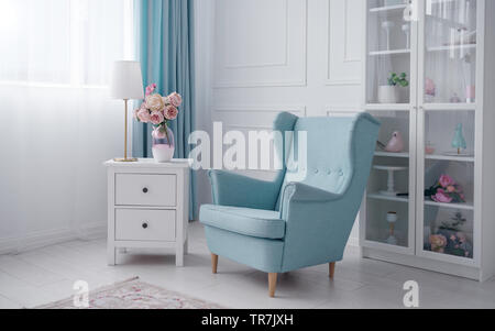 Blue classic Sessel und Nachttisch mit Tischleuchte und Blumen Vase in White Room Stockfoto