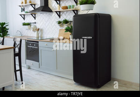 Retro schwarz Kühlschrank in grau Küche aus Holz Stockfoto
