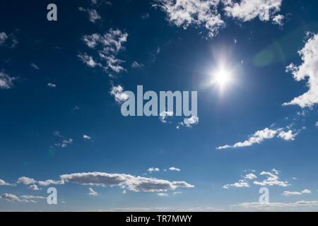 Blauer Himmel mit Sonne und Wolken. Mit lens flare Effekt. Stockfoto
