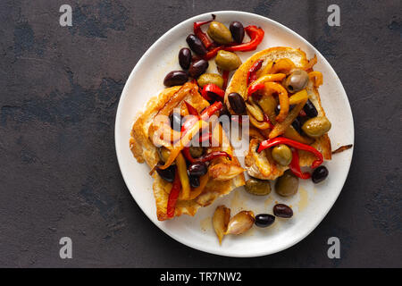 Sandwiches mit gegrilltem Paprika, Oliven und Knoblauch auf einem dunklen Hintergrund, Ansicht von oben. Flach Stockfoto