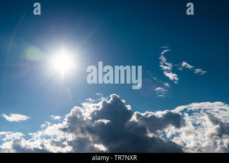 Blauer Himmel mit Sonne und Wolken. Mit lens flare Effekt. Stockfoto