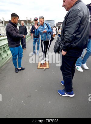 London, England, UK. Illegale Cup und Ball/3 Tassen Trick auf die Westminster Bridge, versuchen, Geld von Touristen zu Con. Die Frau ist ein Handlanger, allo Stockfoto
