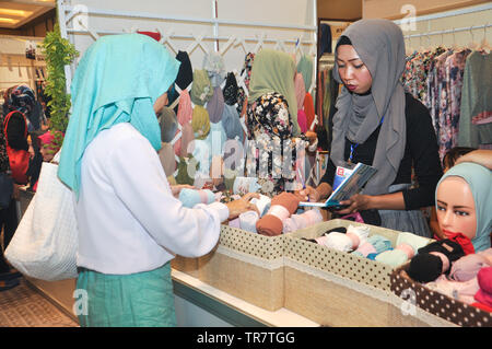 Ein indonesischer muslimische Frau Picks headscarfs oder hijabs an Indonesien Moslem Mode Expo. Muslimische Mode Industrie wächst sehr schnell in Indonesien in den Pa Stockfoto