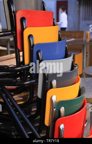 Bunte Stühle gestapelt Vor einem Restaurant Stockfoto