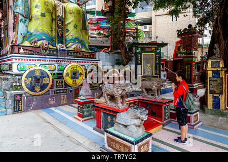 Eine Frau an der Tin Hau (Göttin des Meeres) Statue, Kwun Yam Schrein, Repulse Bay, Hong Kong, China zu beten Stockfoto