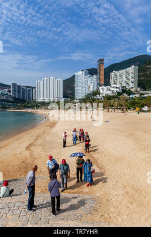 Chinesische Touristen am Strand von Repulse Bay, Hong Kong, China Stockfoto