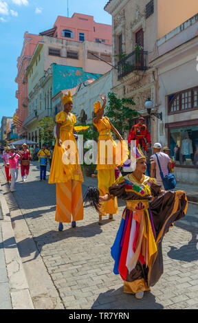 Farbenfroh gekleideten Straßenkünstler in der Altstadt von Havanna, Kuba, manche auf Stelzen mit einer Band spielen folgende an der Rückseite. Stockfoto