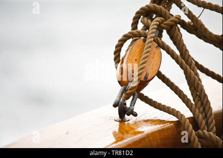 Block und Seile Anschließen an ein Geländer auf der Erneuerung eines alten Fischereifahrzeuges. Stockfoto