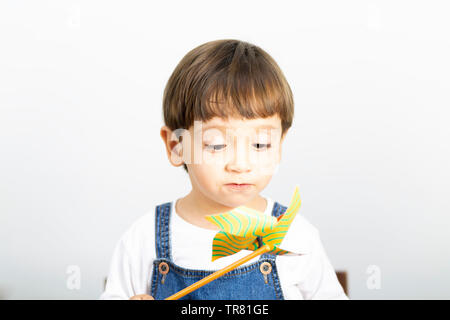 Wenig glücklich Junge spielt mit Windrad, Wind spielen Stockfoto