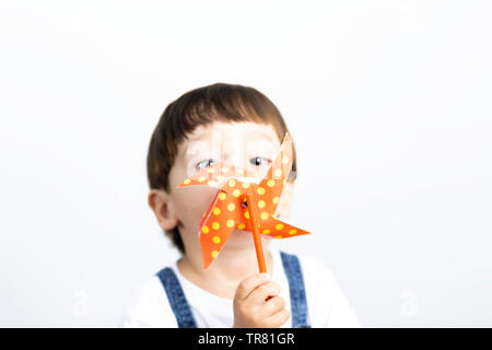 Wenig glücklich Junge spielt mit Windrad, Wind spielen Stockfoto