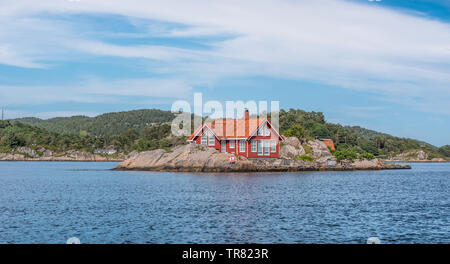 Ein rotes Haus auf einer kleinen Insel Stockfoto