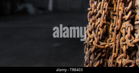 Nicht verwendete und rostige Schneeketten hing von der Wand. Stockfoto