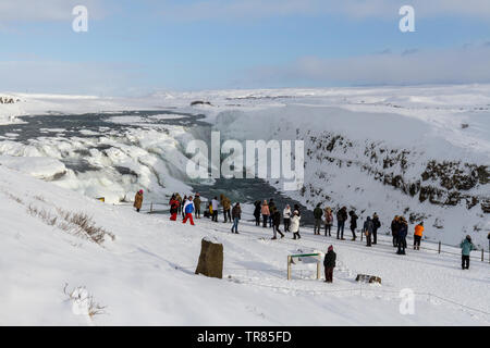 Touristen aufgereiht vor der atemberaubenden Gullfoss Wasserfall auf dem Fluss Hvítá im südlichen Island. Stockfoto