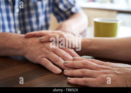 Nahaufnahme von Frau tröstend Unglücklich älterer Mann sitzt in der Küche zu Hause. Stockfoto