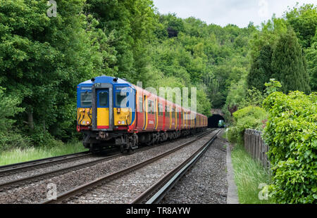 Eine Klasse 455 South Western Railway Passenger service Zug nähert sich einem Tunnel in die Landschaft von Surrey in Norbury Park, in Richtung London. Stockfoto