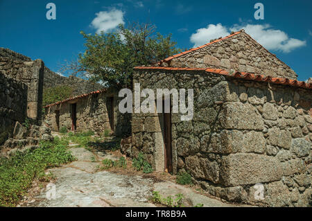 Gotisches Haus aus Stein in Gasse am Hang über felsiges Gelände und Wand bei Sortelha. Eine erstaunliche und gut erhaltene mittelalterliche Weiler in Portugal. Stockfoto