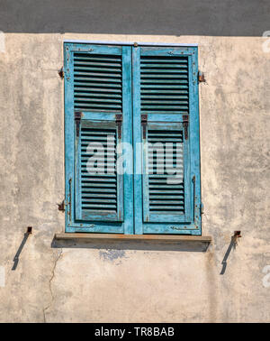 Foto eines einsamen verwitterten, blau grün Holz Fensterläden gegen eine Blasse gelb Putz an der Wand. In den Cinque Terre Italien. Stockfoto