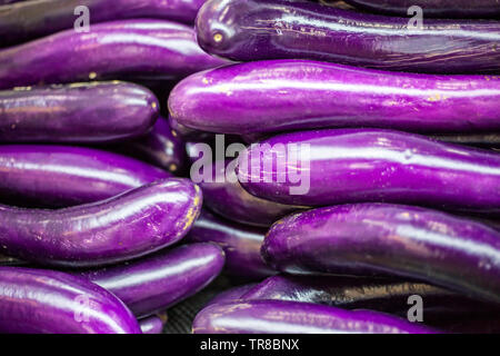 Lange lila Chinesische Auberginen Früchte, auch als Aubergine oder Aubergine Früchte bekannt. Blumensträuße frisch lange Chinesische Auberginen am Farmers Market Stockfoto