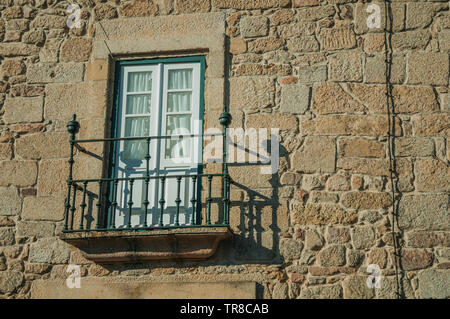 Balkon mit schmiedeeisernen Geländer und verglaste Tür auf einer Steinmauer in Guarda. Das gut erhaltene mittelalterliche Stadt in der östlichen Portugal. Stockfoto