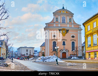 BAD ISCHL, Österreich - 20. FEBRUAR 2019: Die bescheidene Fassade der St. Nikolaus Pfarrkirche, mit Relief Wappen verziert, Gesichter Franz Joseph Strasse Stockfoto