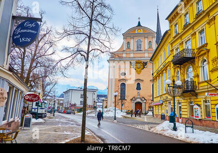 BAD ISCHL, Österreich - 20. FEBRUAR 2019: Die Aussicht auf die malerische Fassade der St. Nikolaus Pfarrkirche hinter der reich verzierte Gebäude, in Franz Joseph entfernt Stockfoto