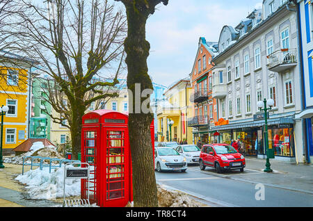 BAD ISCHL, Österreich - Februar 20, 2019: Das Straßenbild in den Kreuzplatz mit Vintage rote Telefonzelle und historischen Bauten auf Hintergrund, auf Februar Stockfoto