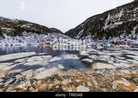 Waterfront mit schwebenden Pfannkucheneis am Ausgang von Grey River, die zusammen ein Fjord gekuschelt wird, gesehen von der Fähre Marine Voyager, Neufundland Stockfoto