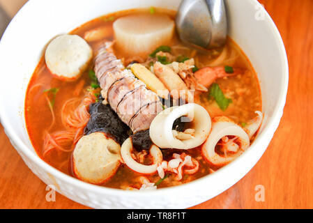 Heiß und würzig Thai Essen Nudeln mit Meeresfrüchten Soup Bowl Chilipaste Sauce und Limettensaft mit Mantis shrimp squid Fisch und Krabben - Tom Yam, thailändischen Stil Essen Stockfoto