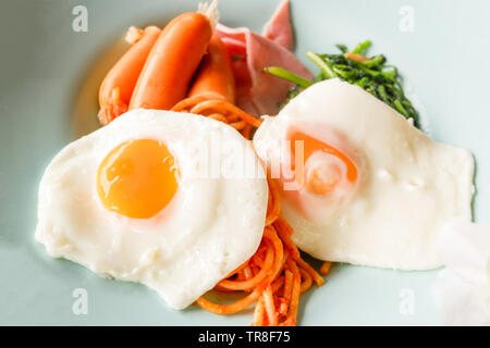 Frühstück Spiegelei Wurst und Spaghetti auf dem Teller Stockfoto