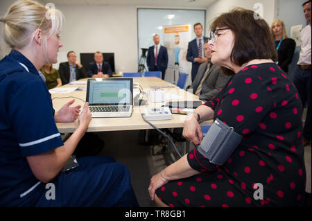 East Kilbride, UK. 30. Mai 2019. EMBARGO BIS ZUM 31. Mai um 00:01 Bild: (links-rechts) Laura MacKinnon, Jeane Freeman. Neue Technologie, die es erlaubt, dass Patienten ihren Blutdruck zu Hause zu überwachen wird über Schottland gerollt werden. Die scale-up BP Initiative verringert die Notwendigkeit für GP Konsultationen, und kann helfen, genauere Messwerte zu liefern. Die Patienten werden gezeigt, wie sie ihre eigenen Blutdruck und Text die Ergebnisse eine App namens Florenz, oder Flo zu messen. Colin Fisher/Alamy leben Nachrichten Stockfoto