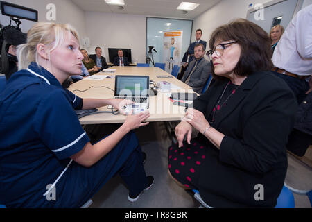 East Kilbride, UK. 30. Mai 2019. EMBARGO BIS ZUM 31. Mai um 00:01 Bild: (links-rechts) Laura MacKinnon, Jeane Freeman. Neue Technologie, die es erlaubt, dass Patienten ihren Blutdruck zu Hause zu überwachen wird über Schottland gerollt werden. Die scale-up BP Initiative verringert die Notwendigkeit für GP Konsultationen, und kann helfen, genauere Messwerte zu liefern. Die Patienten werden gezeigt, wie sie ihre eigenen Blutdruck und Text die Ergebnisse eine App namens Florenz, oder Flo zu messen. Colin Fisher/Alamy leben Nachrichten Stockfoto