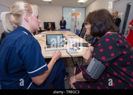 East Kilbride, UK. 30. Mai 2019. EMBARGO BIS ZUM 31. Mai um 00:01 Bild: (links-rechts) Laura MacKinnon, Jeane Freeman. Neue Technologie, die es erlaubt, dass Patienten ihren Blutdruck zu Hause zu überwachen wird über Schottland gerollt werden. Die scale-up BP Initiative verringert die Notwendigkeit für GP Konsultationen, und kann helfen, genauere Messwerte zu liefern. Die Patienten werden gezeigt, wie sie ihre eigenen Blutdruck und Text die Ergebnisse eine App namens Florenz, oder Flo zu messen. Colin Fisher/Alamy leben Nachrichten Stockfoto