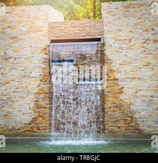 Steine, Ziegel und Wasserfall und Wasser Teich schönes Design schmücken im Garten Stockfoto