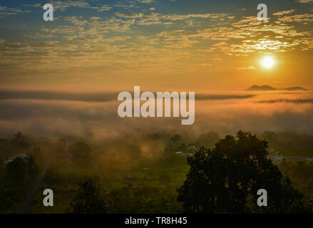 Nebel Sonnenaufgang über Winter schöner Morgen mit misty Abdeckung auf der Wiese und das Dorf Landschaft Landschaft Asien Stockfoto