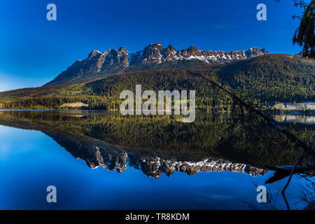 Berge im Morgenlicht in ruhigen See Wasser wider Stockfoto